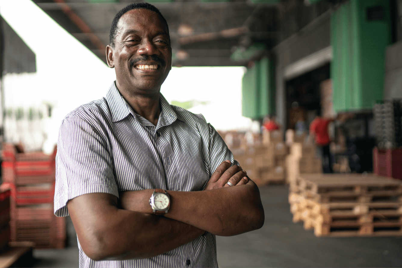 Smiling man with arms folded in a forwarding department